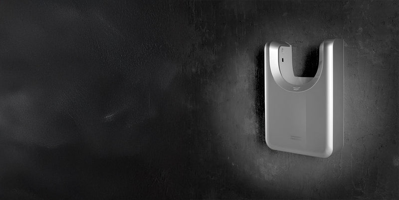 Silberner Händetrockner Dyson Airblade-Jet, hochkant an dunkler Wand montiert, U-förmige Öffnung oben für Hände