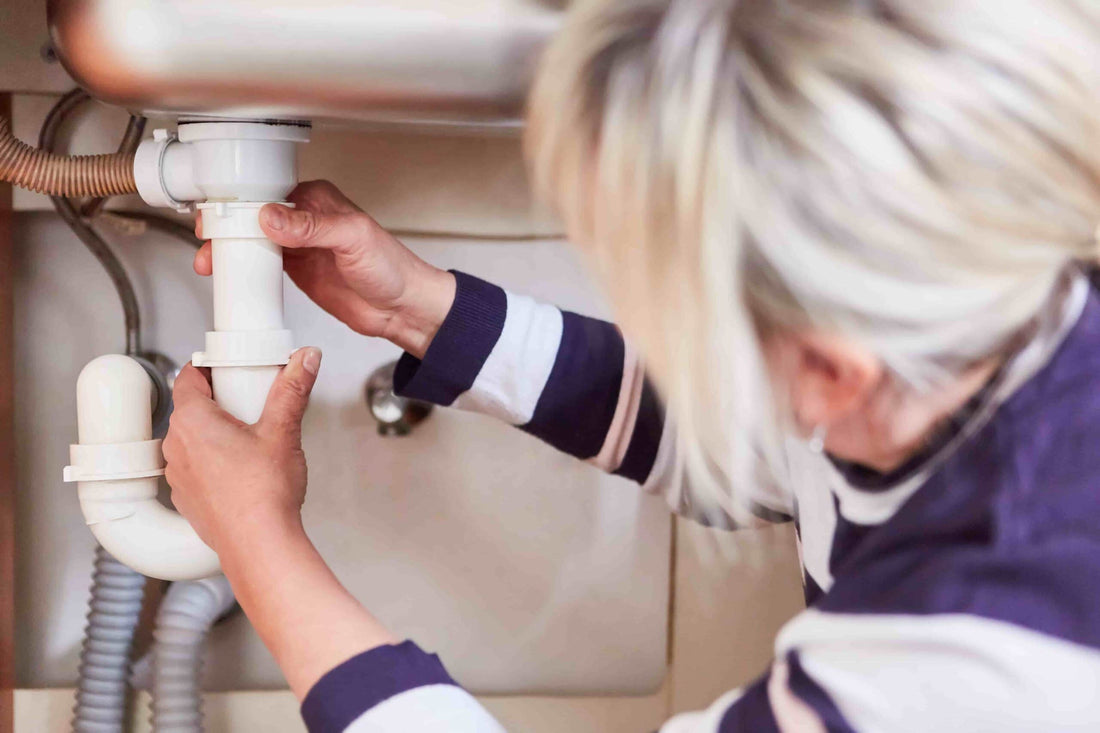 Person reinigt Küchensiphon einfach