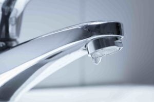 Nahaufnahme eines tropfenden Wasserhahns – was tun bei undichter Armatur?